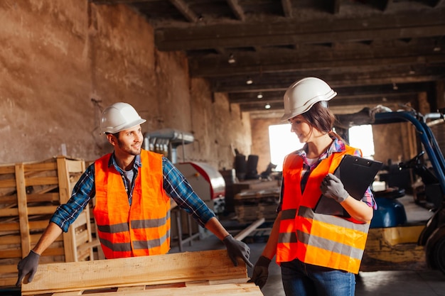 The woman inspector checks the work of a man in a warehouse