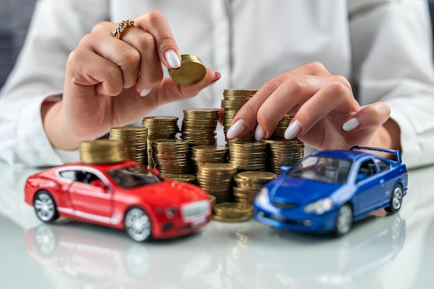 Woman insurance representative sitting at a table with coins and a mini car