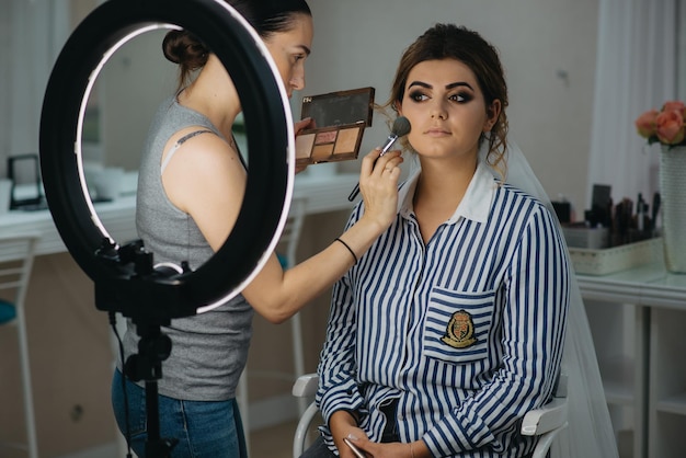 A woman is applying makeup in a makeup studio.