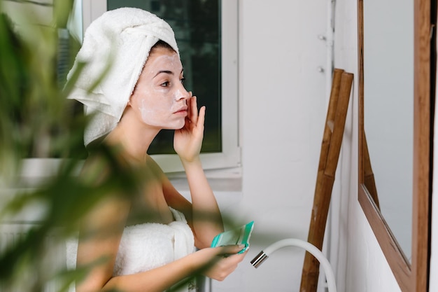 Woman is applying mask on her face