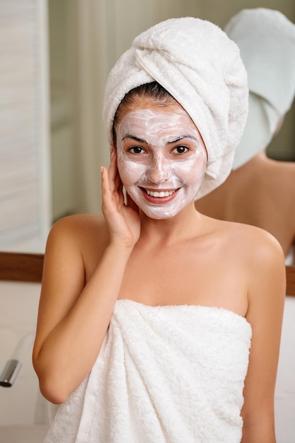 Woman is applying mask on her face