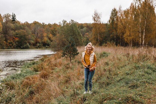 The woman is in the autumn park Autumn atmosphere scenic view of the river