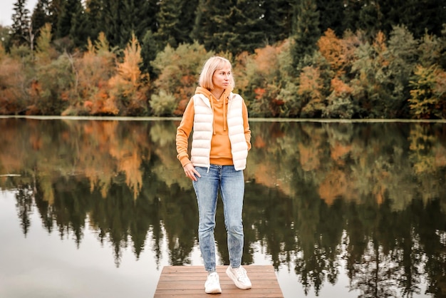 The woman is in the autumn park Autumn atmosphere scenic view of the river