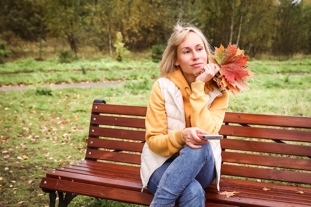 The woman is in the autumn park Autumn atmosphere