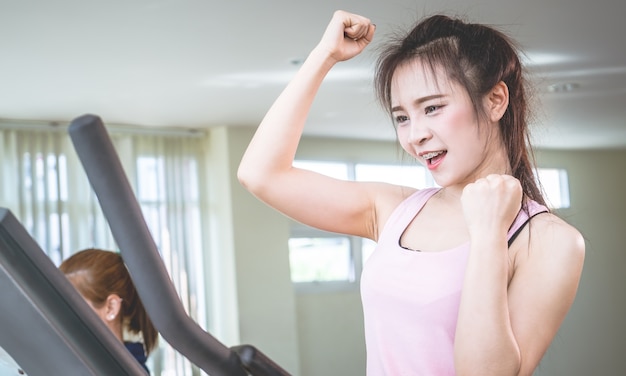 Woman is celebrating her success in fitness gym workout