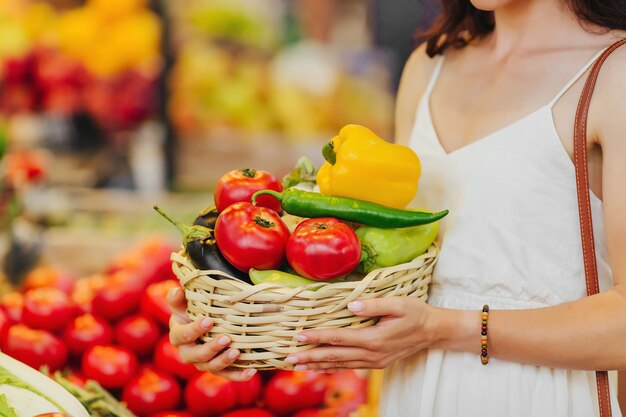 Woman is chooses  fruits and vegetables at food market.