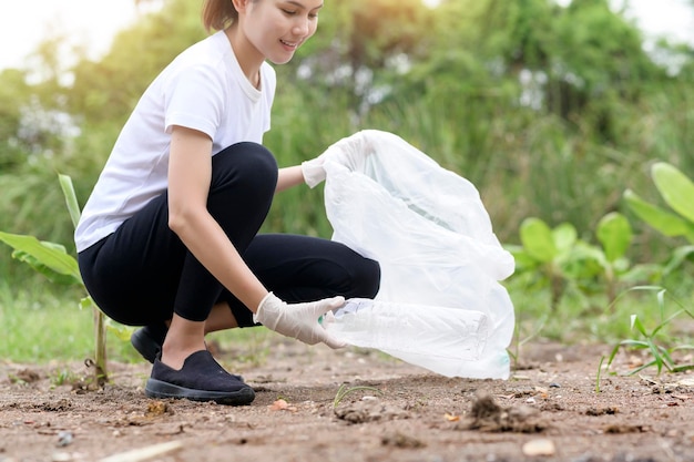 Woman is collecting recycling junk on ground ecological sustainable concept