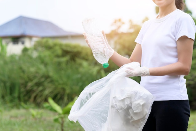 Woman is collecting recycling junk on ground ecological sustainable concept