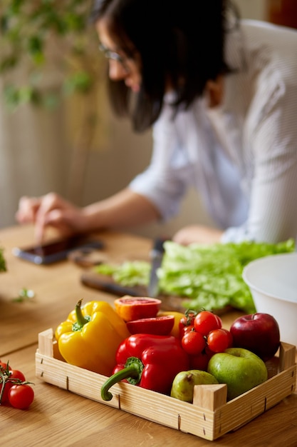 Woman is cooking in the kitchen at home, using digital tablet