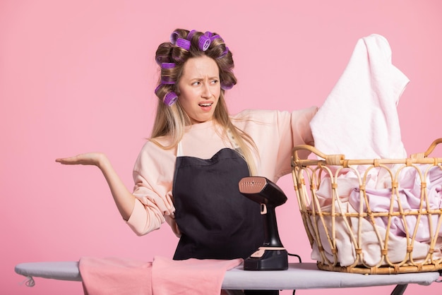 The woman is dissatisfied with doing household chores she pulls washed clothes out of the basket