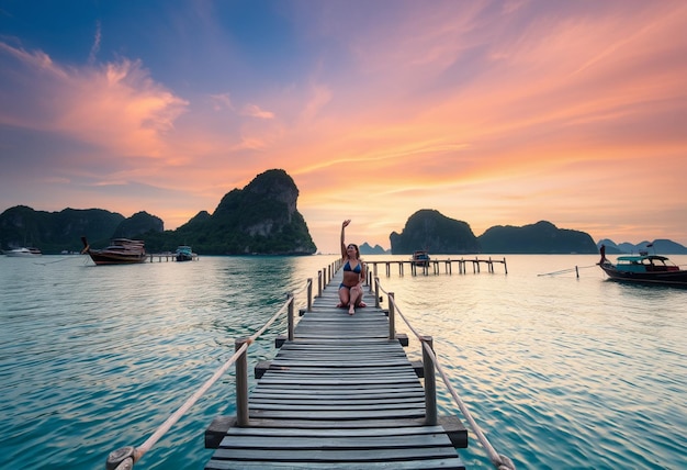 a woman is on a dock with a sunset in the background