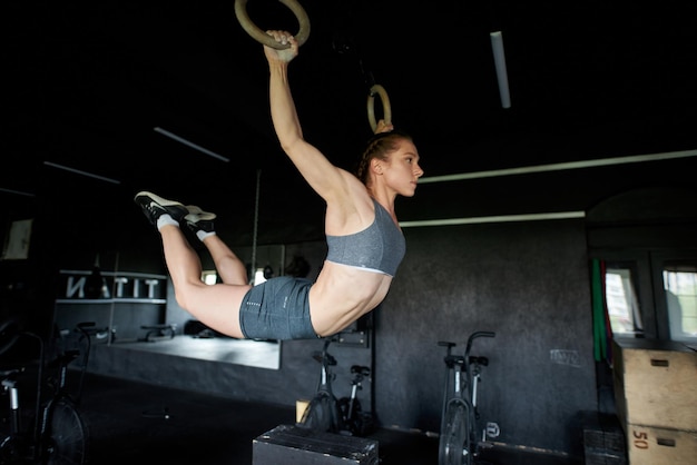 A woman is doing a pulley on a bar.