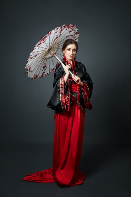 Woman is dressed in red Chinese Japanese folk clothing.