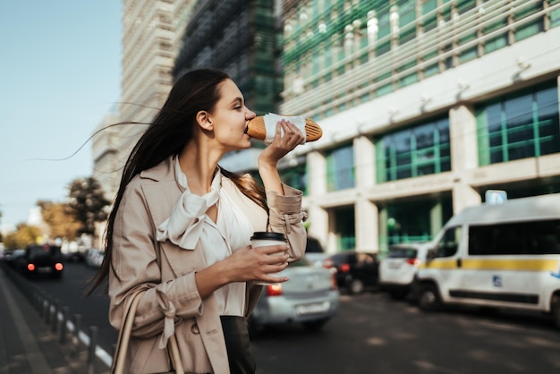 A woman is drinking coffee and kissing on the street