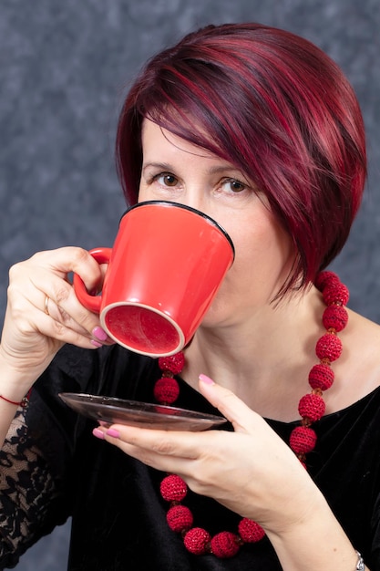 A woman is drinking from a red cup