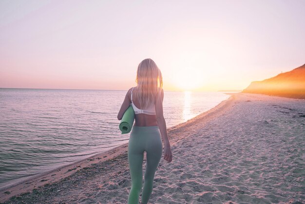 Woman is engaged in sports exercise on the beach