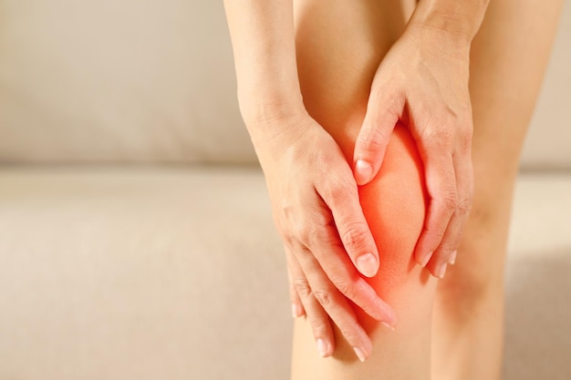 A woman is feeling knee pain when going up and down stairs running or jumping