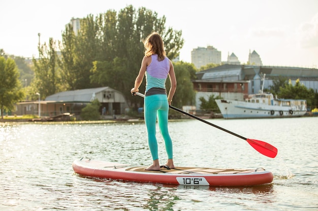 Woman is floating on a sup board on sunny morning stand up paddle boarding  awesome active recreatio...