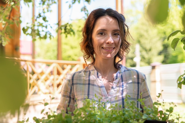 A woman is gardening in her backyard she plants seedlings