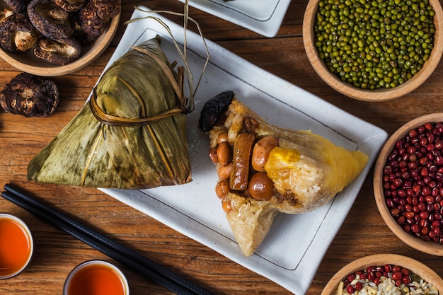 A woman is giving zongzi (rice dumpling) to others as a present on Dragon Boat Festival