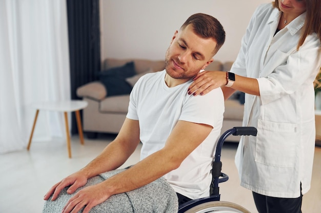 Woman is helping Disabled man in wheelchair is at home