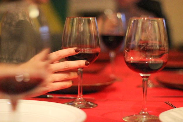 A woman is holding a glass of red wine.