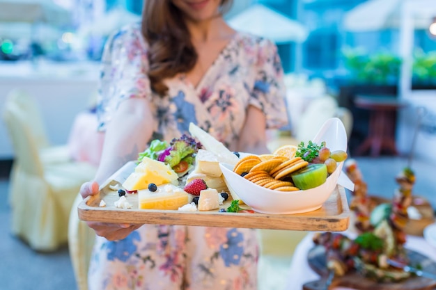 Woman is holding healthy breakfast of cheese biscuits and fresh fruit