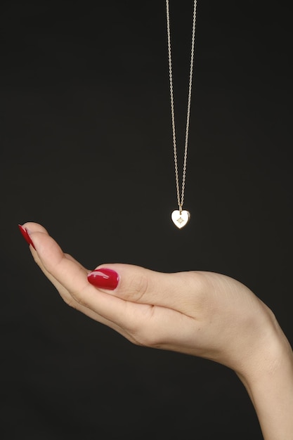 a woman is holding a necklace with a necklace in her hand