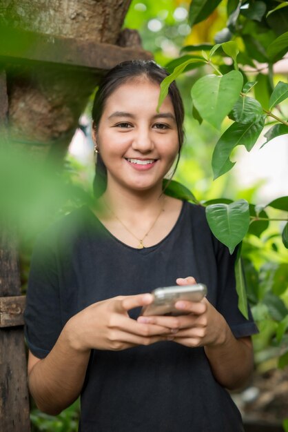 Photo a woman is holding a phone and smiling