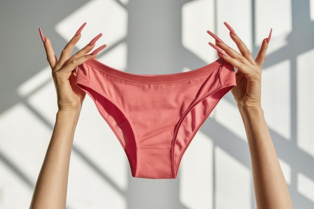 Photo a woman is holding a pink underwear that has the number 5 on it