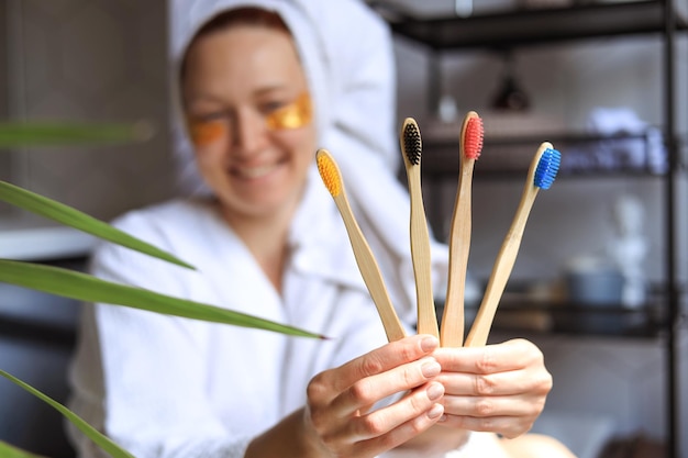 A woman is holding a set of bamboo wooden toothbrushes Eco friendly concept of dental care and dental health