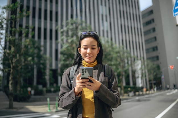 a woman is looking at her phone while wearing a yellow scarf