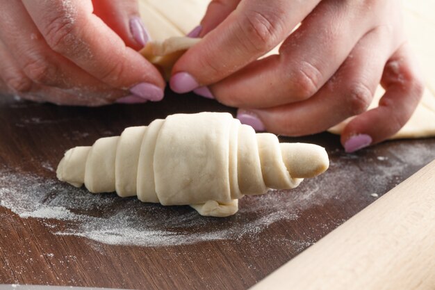 Woman is making croissant in the kitchen