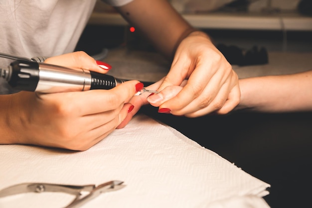 Woman is making a manicure. Salon procedures at home. Beautiful hands and nails.