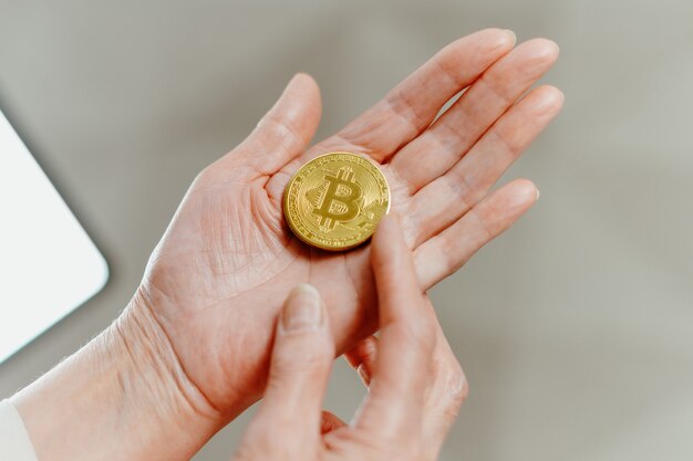 Woman is pointing at the bitcoins in her palm