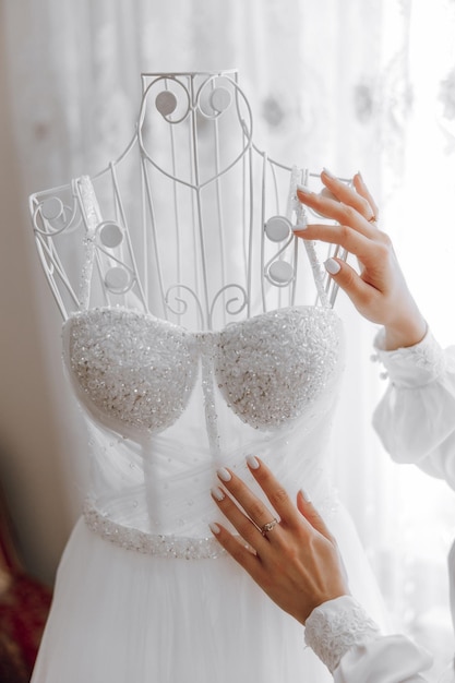 Photo a woman is putting a white dress on a mannequin