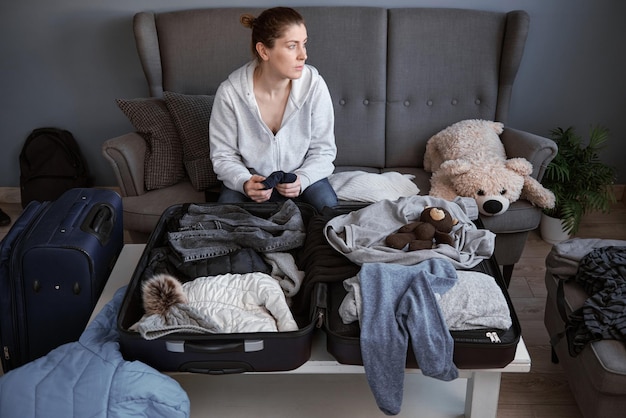 A woman is ready to leave her house and packing things in a suitcase Refugees