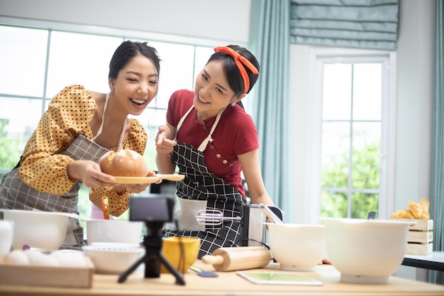 A woman is showing a bread that she has made to her friend