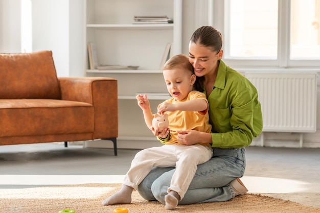 A woman is sitting on the floor engaging with a baby mother is interacting with the baby by playing