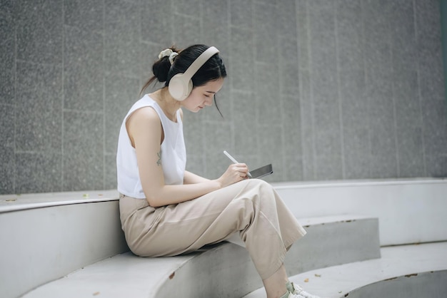 a woman is sitting on a step with a pen and paper