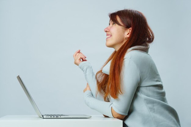 Woman is sitting at table and using laptop for communication in chat or video chat Social media concept