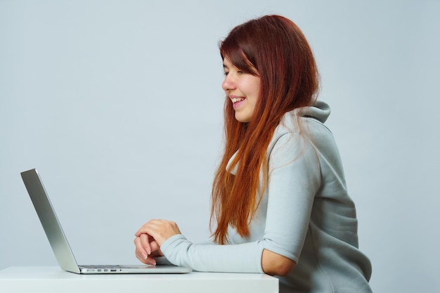 Woman is sitting at table and using laptop for communication in chat or video chat Social media concept