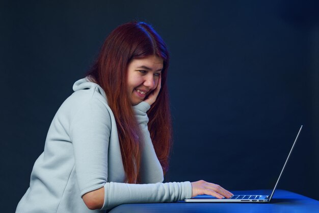 Woman is sitting at table and using laptop for communication in chat or video chat Social media concept