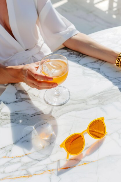 Photo a woman is sitting at a table with a glass of ice water and a pair of sunglasses