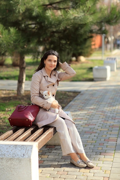 a woman is sitting with a puppy in her arms on a bench