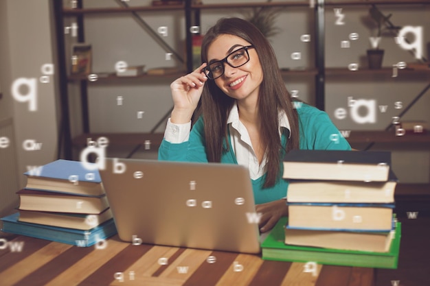 Woman is smilling She is working with lots of books and laptop