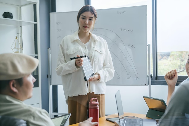 a woman is standing in front of a whiteboard with a graph on it