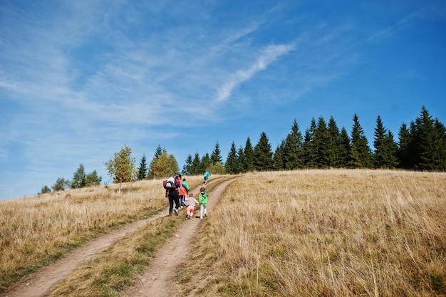 Woman is traveling with a childrens Mom in the mountains Climb to the top of the mountain with children With the backpack climbed to the top