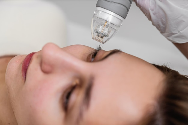 A woman is undergoing a laser treatment on her eye with the help of a specialist ensuring safety and