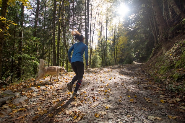 a woman is walking down a path in the woods